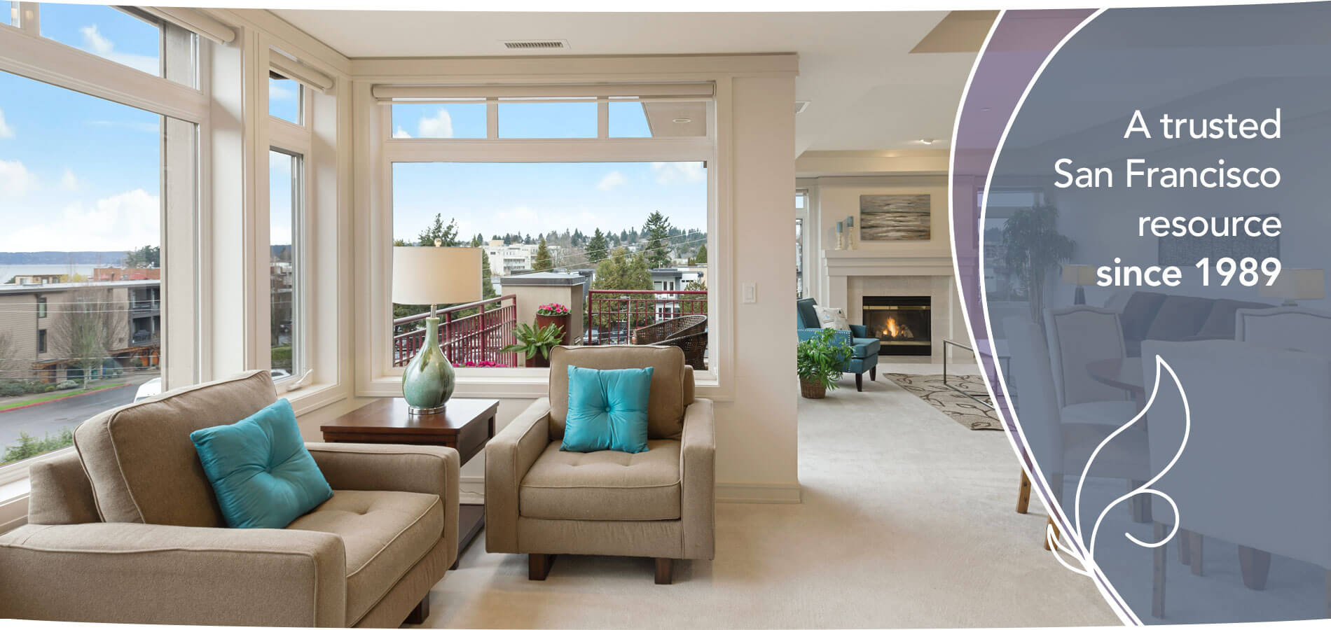 Sunlit San Francisco living room with armchairs, a fireplace, and city views — Primavera Realty