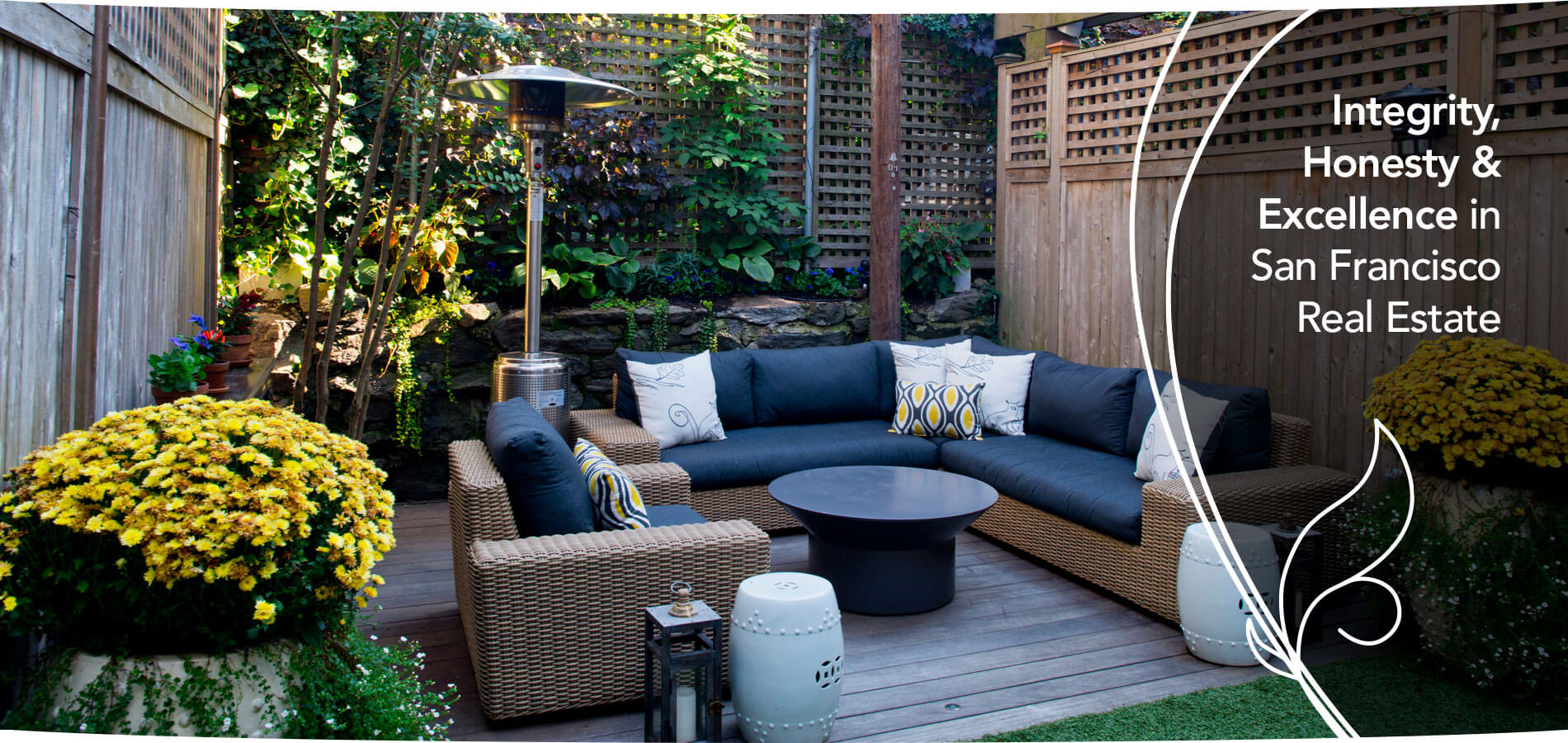 Landscaped San Francisco backyard patio with wicker seating and a lush garden — Primavera Realty